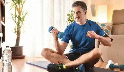 Middle-aged man exercising with dumbbells at home, focusing on fitness and testosterone replacement therapy for men over 40.